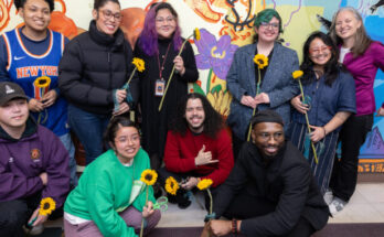 The class of muralists posing in front of the newly unveiled mural.