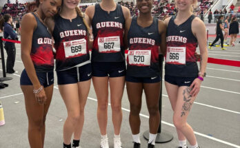 Runners from the Queens College women’s track and field team pose for a photo.
