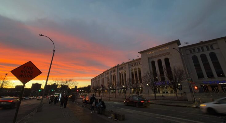 Sunset at Yankee Stadium as people wait for the bus.