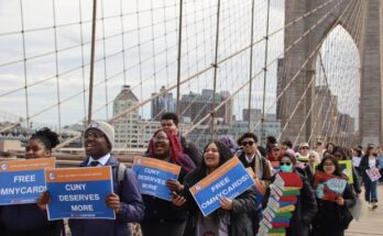 Students march across the Brooklyn Bridge toward City Hall, holding signs and chanting.