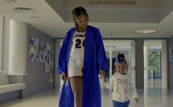 A still from a CUNY commercial showing a graduate holding hands with a child.