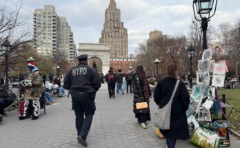 A NYPD officer walks in Washington Square Park.
